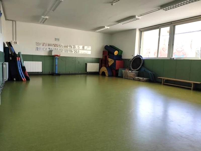 Sala de psicomotricitat amb matalassos, peces d’escuma i material de moviment.